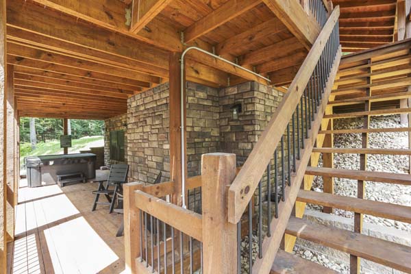 Shagbark Hickory Ridge, Hocking Hills — lower deck hot tub with deck chairs and stone wall