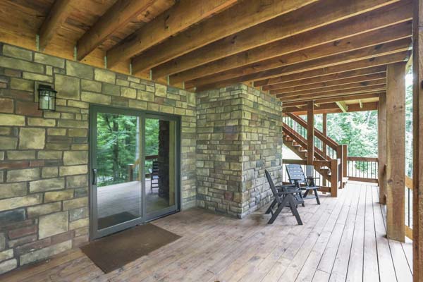 Shagbark Hickory Ridge, Hocking Hills — lower-level covered deck with stone columns and sliding door